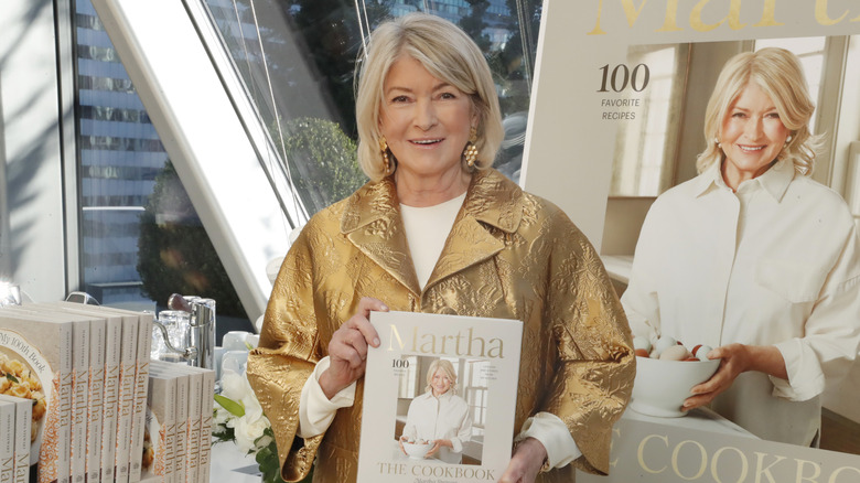 Martha Stewart poses with one of her cookbooks