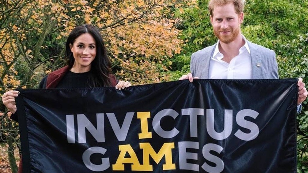 Meghan Markle and Prince Harry holding sign