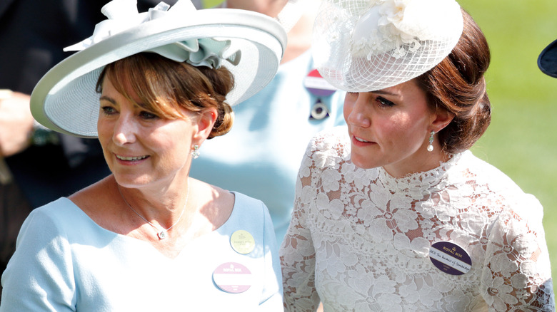 Carole and Kate Middleton stand side by side, looking off to the right