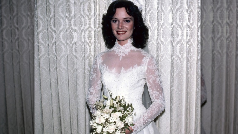 Emily Ruth Black posed in her wedding gown holding flowers