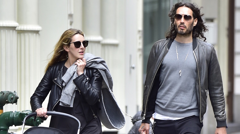 Russell Brand and his wife Laura walking outside