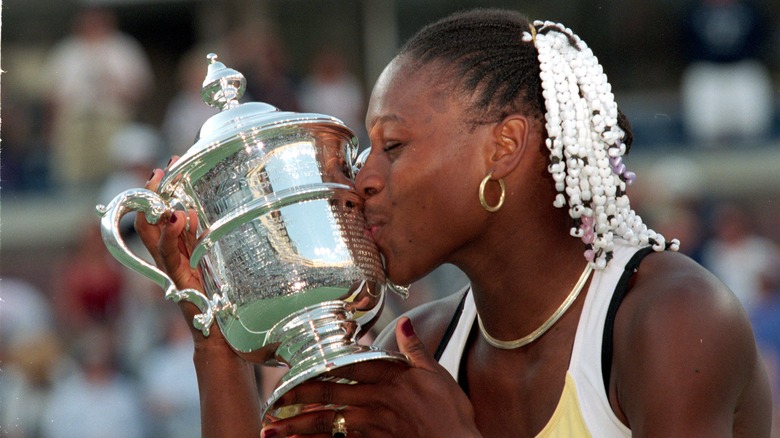 Serena Williams kisses a tennis trophy