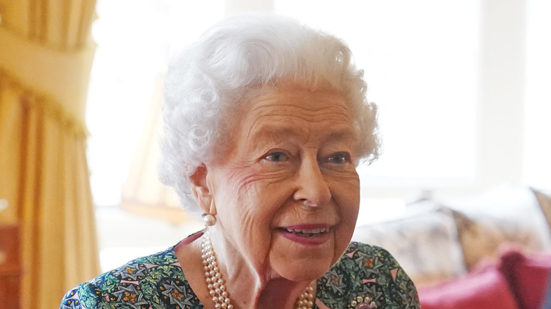 The Queen wearing a flowery dress and pearls