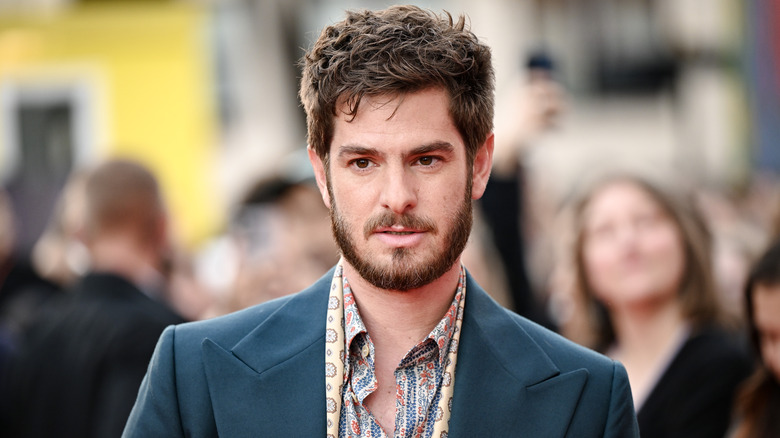 Andrew Garfield posing in a paisley shirt and navy jacket