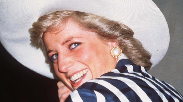 Princess Diana wearing an oversized hat and looking back over her shoulder