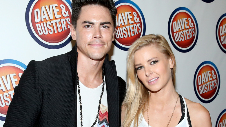 Tom Sandoval and Ariana Madix posing in front of Dave & Busters sign