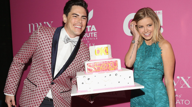 Tom Sandoval and Ariana Madix on red carpet holding cake