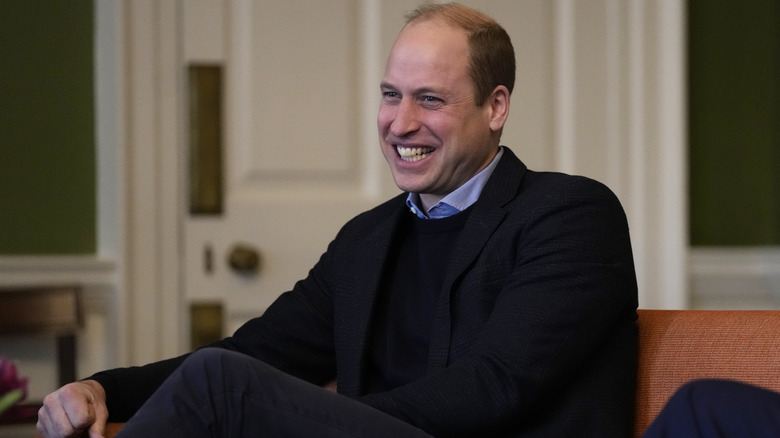 Prince William laughing while seated 