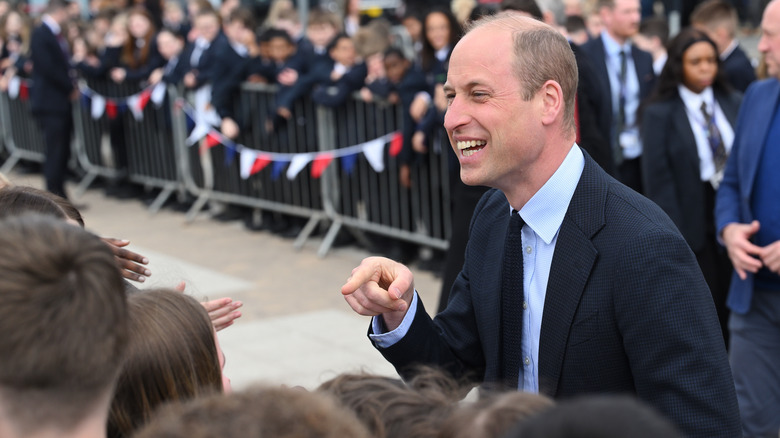 Prince William smiling while interacting with citizens