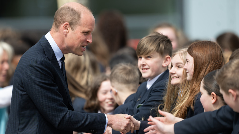 Prince William greeting kids