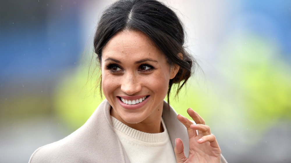 Meghan Markle smiling and waving at the camera