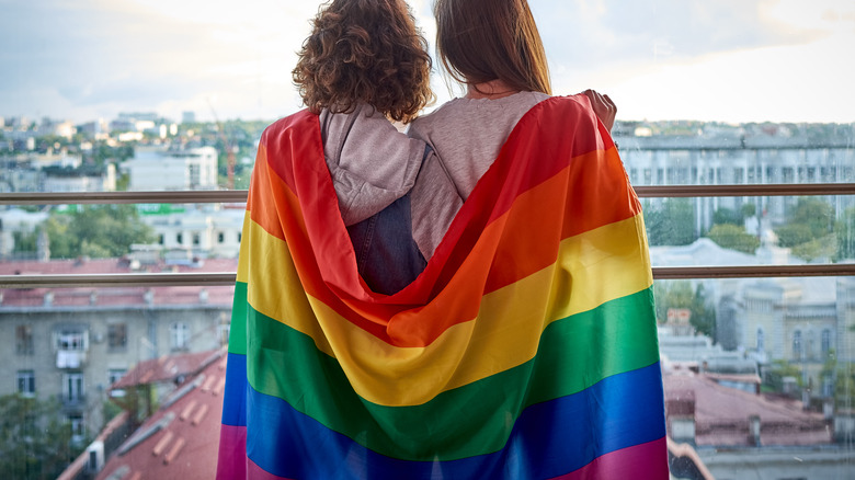 Rainbow flag draped over people