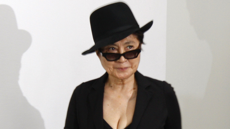 Yoko Ono posing at an art exhibit