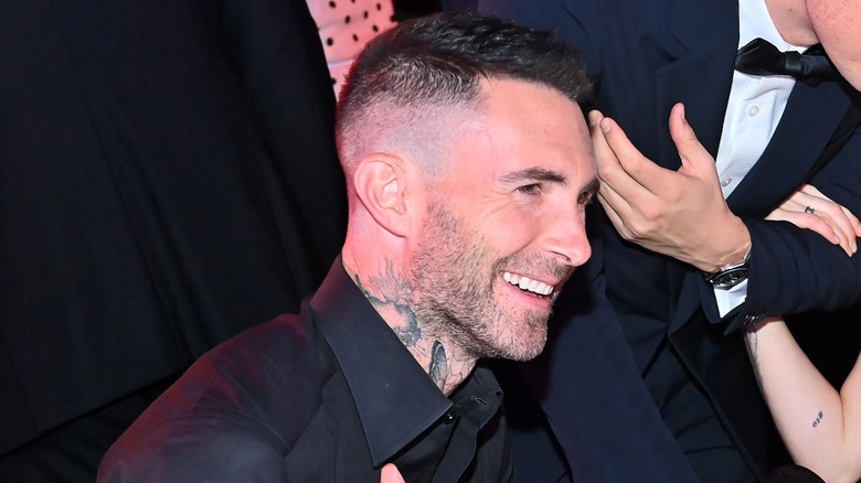 Adam Levine smiling in black shirt 