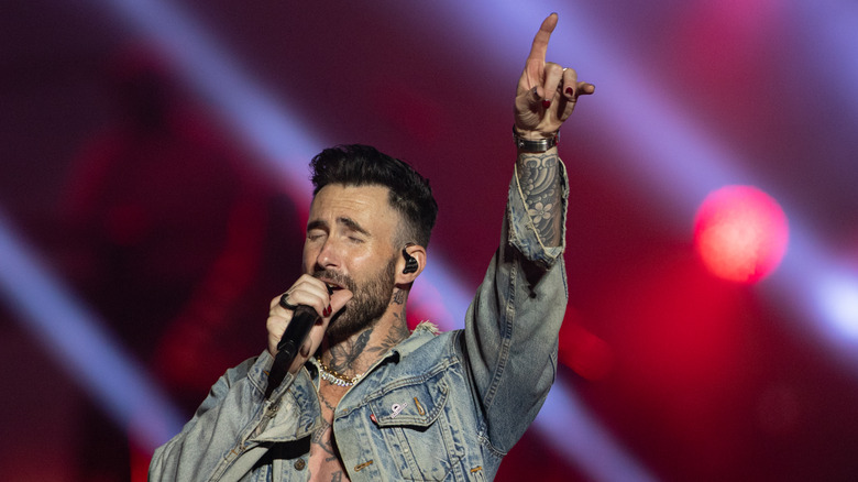 Adam Levine singing in denim jacket