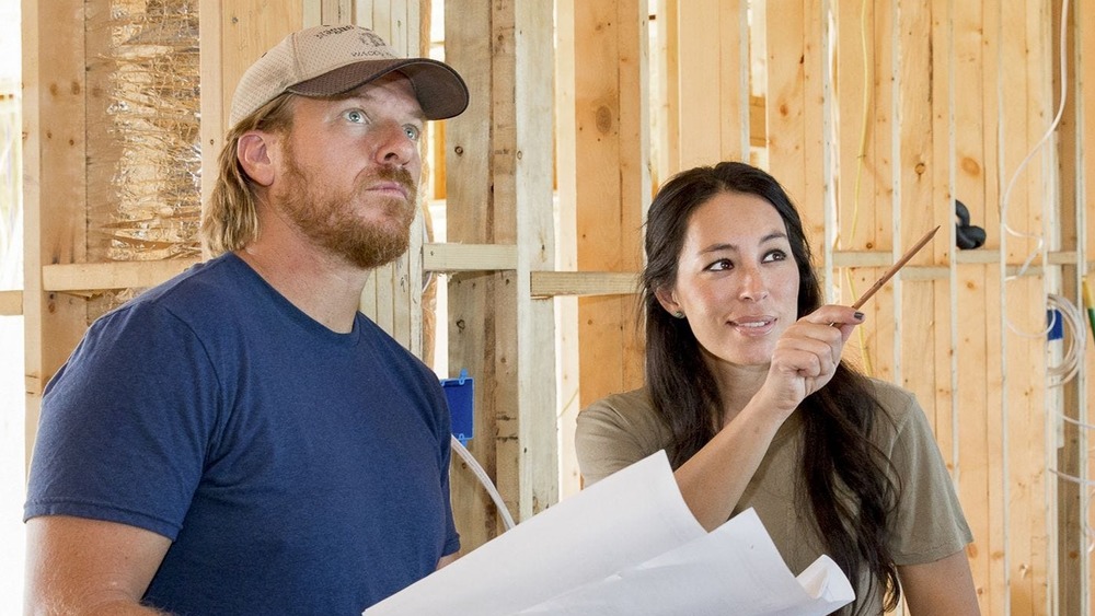Chip and Joanna Gaines on Fixer Upper in front of beams