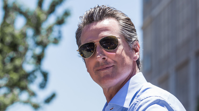 Gavin Newsom smiling with sunglasses on