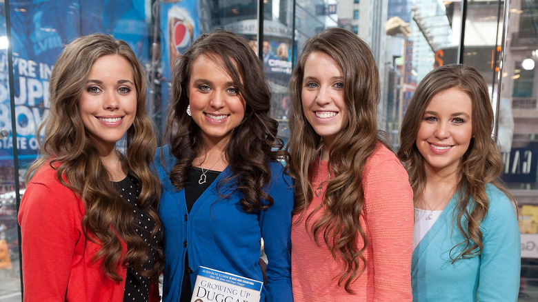 Jinger Duggar, holding Growing Up Duggar, her sisters, 