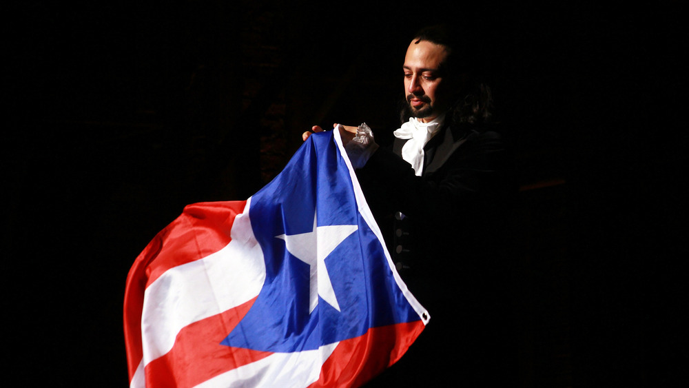 Lin-Manuel Miranda as Alexander Hamilton holding Puerto Rican flag