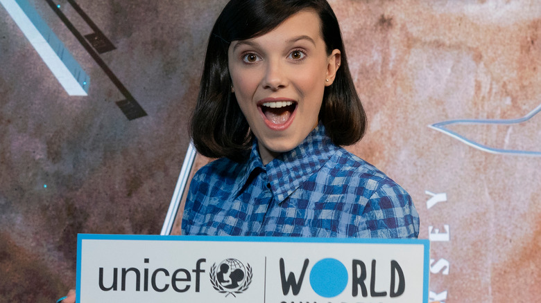 Millie Bobby Brown posing with a UNICEF sign