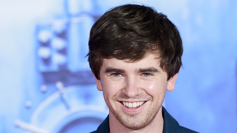 Freddie Highmore with a blue background
