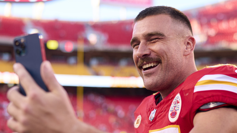 Travis Kelce laughing at phone