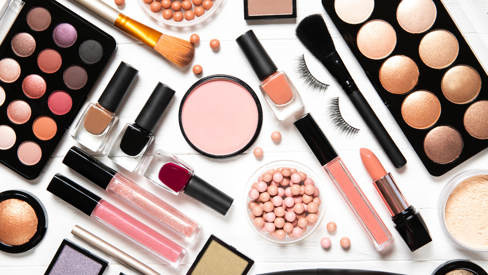 Cosmetics strewn across a white background 