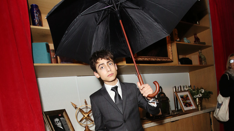 Aidan Gallagher at Umbrella Academy event with an umbrella