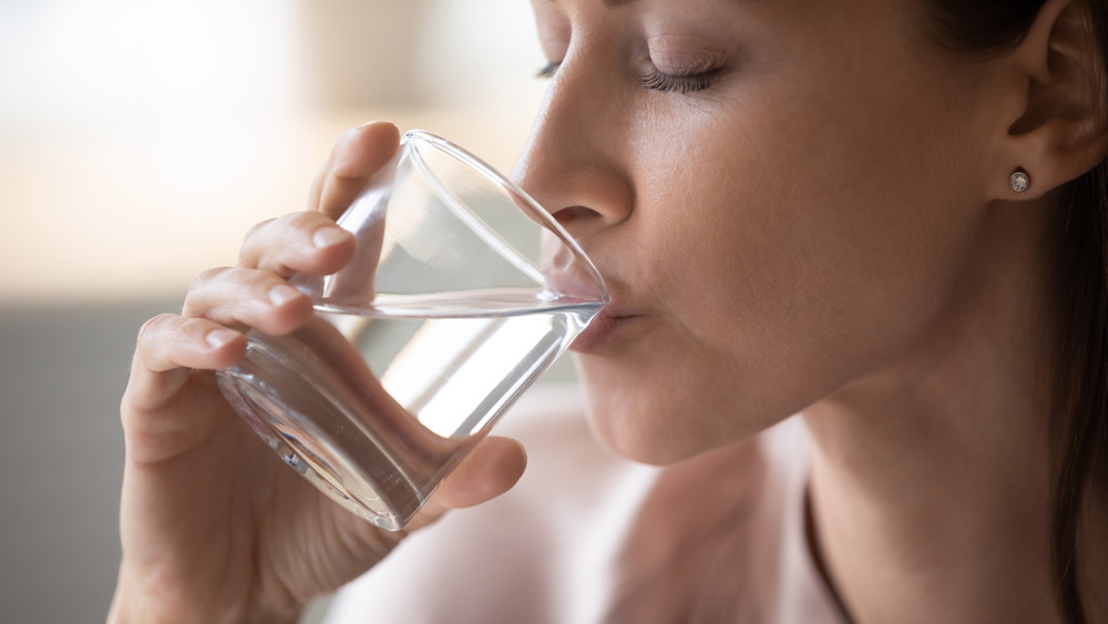 A woman drinking a glass of water