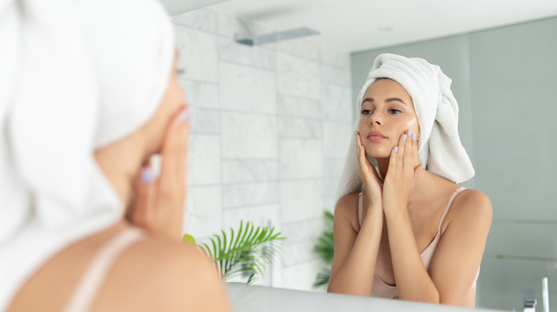 A woman applying skincare products 