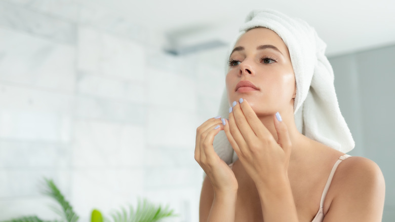 A woman wearing a bath towel over her head.