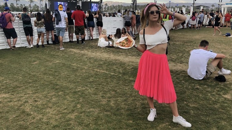 Billie Lourd holding a slice of pizza