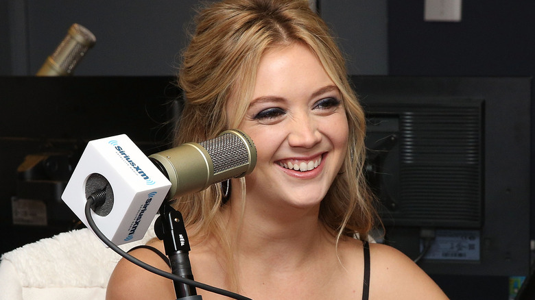 Billie Lourd smiling with a microphone