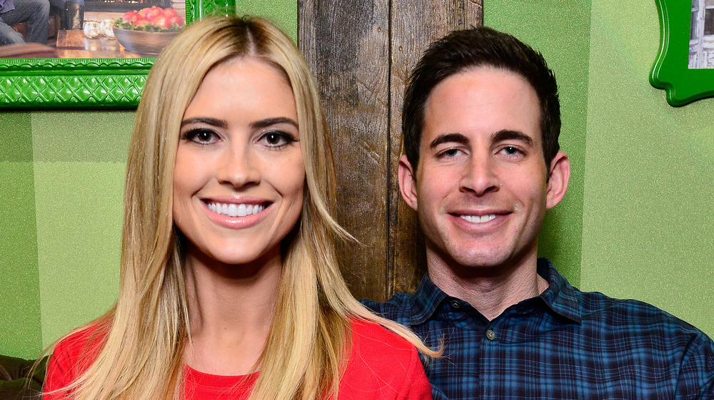 Christina Anstead and Tarek El Moussa in front of a green wall