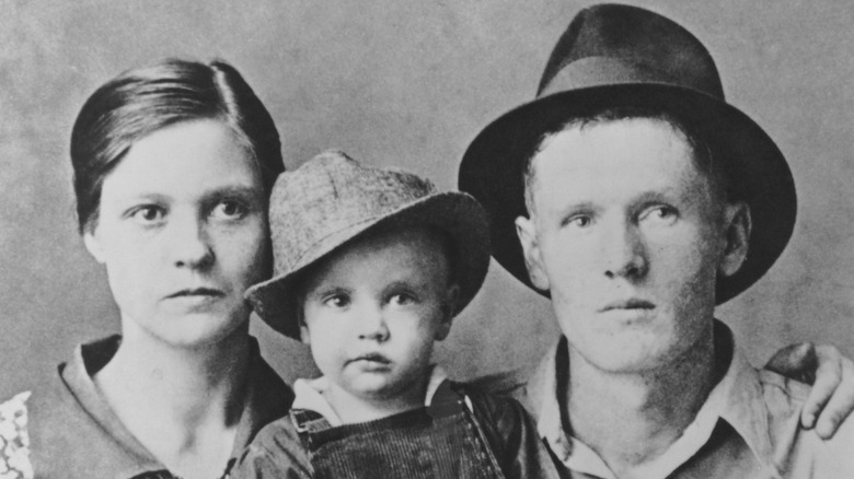 Elvis Presley and his mother and father posing for a photo