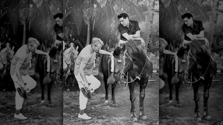 Elvis Presley on a movie set riding a horse