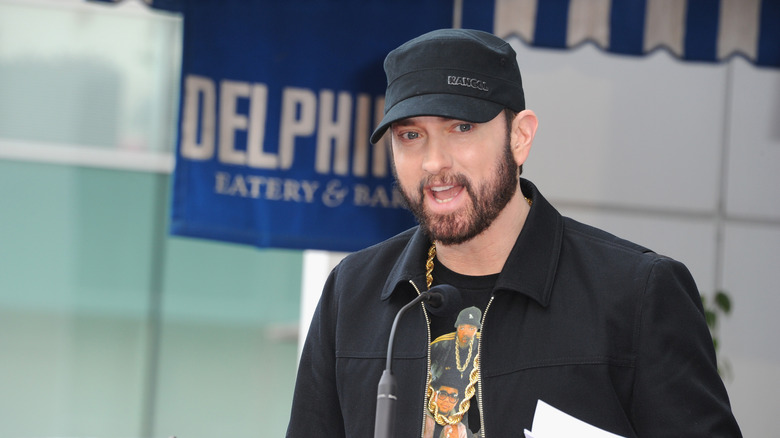 Eminem speaking, wearing baseball cap