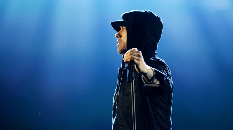 Eminem performing, wearing hat, hood