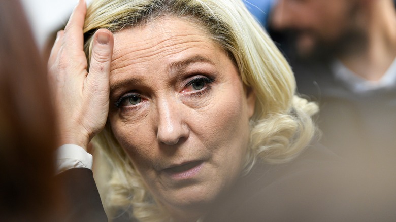 Marine Le Pen with her hands on her head