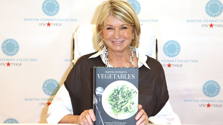 Martha Stewart holding a cookbook