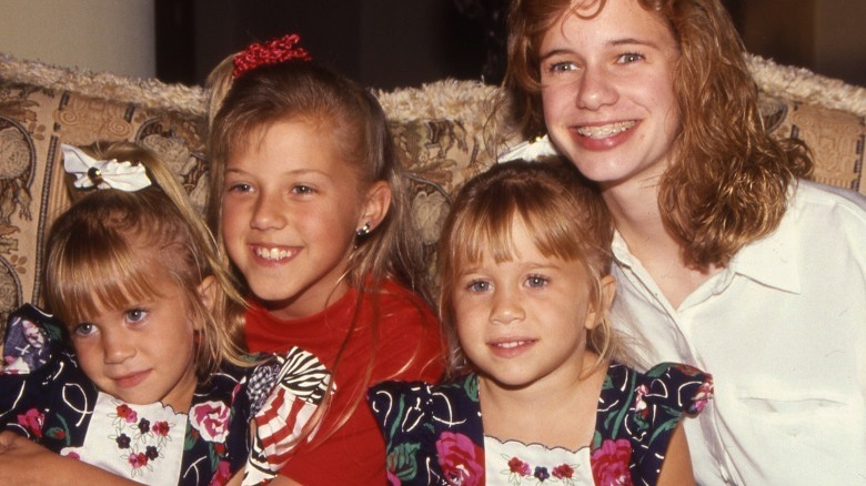 Mary-Kate and Ashley Olsen smiling with "Full House" costars