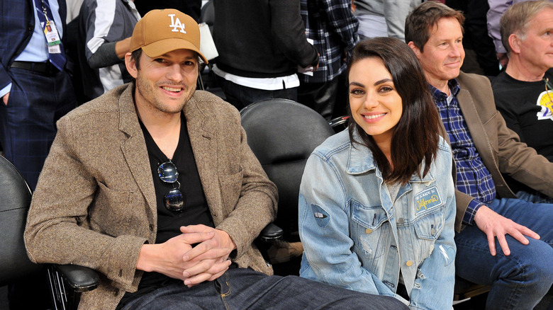 Ashton Kutcher and Mila Kunis at a game