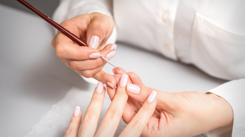 Woman painting french tips for manicure