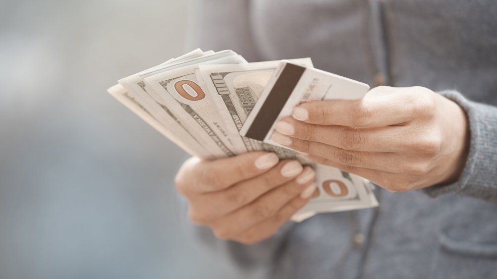 Woman holding cash and credit cards