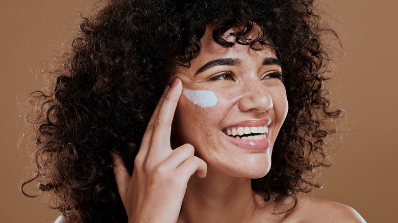 Woman applying sunscreen to her face