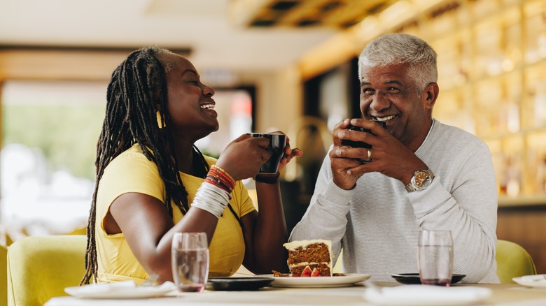 Couple smiling over cake and coffee