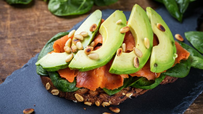 salmon, avocado, and pine nuts on toast