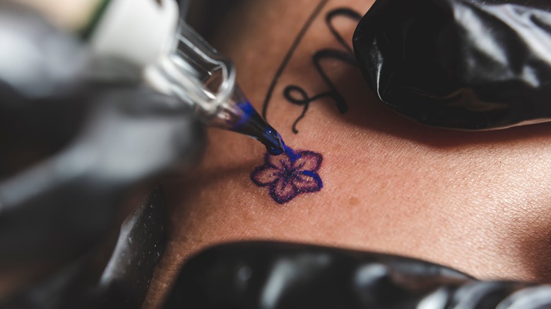 close up of hand giving tattoo