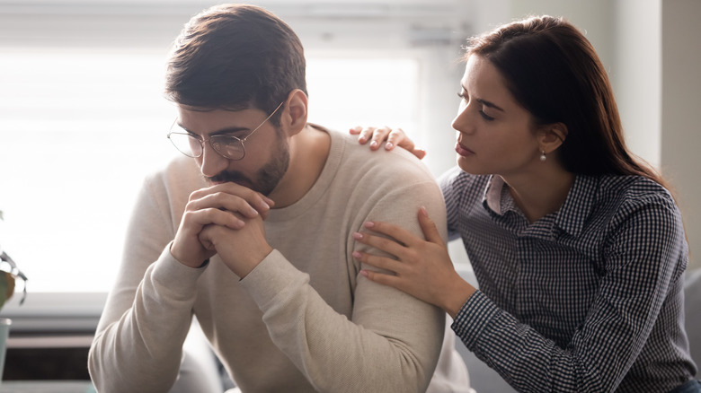 woman comforting man 