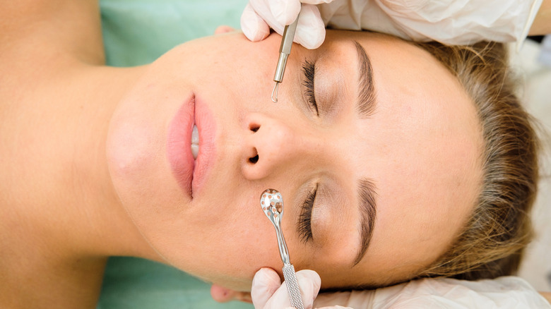 woman with acne getting blackhead extractions